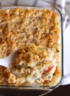 a casserole dish with a spoon full of food and crumbs on it