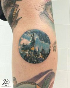 a man with a tattoo on his arm has a hogwarts castle in the middle