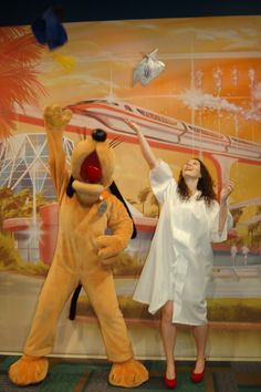 a woman standing next to a large stuffed animal