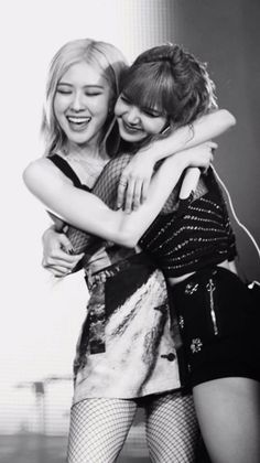 two young women hugging each other in black and white