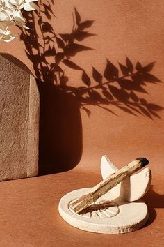 a small white object sitting on top of a table next to a potted plant