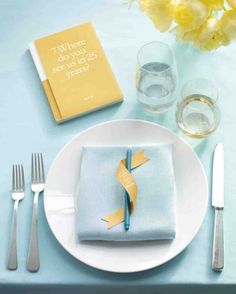 a white plate topped with a napkin and fork next to a glass filled with water