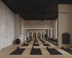 an empty gym with black and white yoga mats