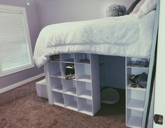 a white loft bed with shelves underneath it