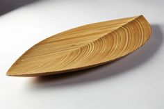 a wooden leaf shaped object sitting on top of a table