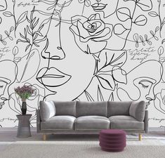 a living room with a couch and wallpaper that has drawings on it, including roses