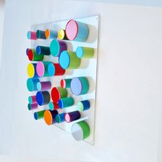 there is a multicolored wall hanging on the wall and it has many circles