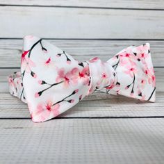 "Pale pink cherry blossoms on white cotton sateen. Because of the handmade nature of these bowties they can vary in size ever so slightly but on average the bow measures 5 inches by 2 inches when tied. hand wash/ spot wash only The self-tied option will be made in the style pictured. The pre-tied option will have the addition of a hook in the back, and the bow will be stitched in the tied position. RETURNS: I accept returns on items in original, unused condition. You will receive a refund for th Elegant Bow For Gift In Spring, Adjustable White Bow Tie With Butterfly Knot, Spring Wedding Bow, Pink Bow Tie For Gift, Pink Bow Tie Gift, Pink Bow Tie As Gift, Pink Bow Tie Perfect As Gift, Elegant Bow Tie For Spring Gifts, Spring Wedding Bow Ties