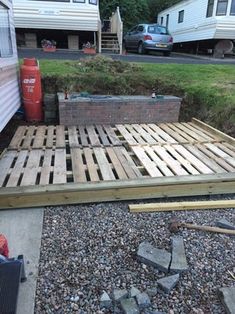 a bed made out of wooden pallets next to a trailer