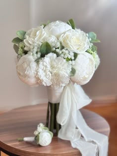 a bouquet of white flowers sitting on top of a table