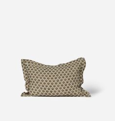 a pillow that is sitting on top of a white surface with a black and brown pattern