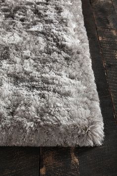 an area rug is shown on a wooden floor with dark wood floors and gray carpeting