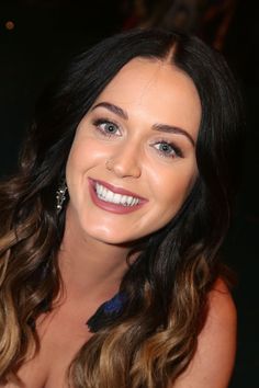 a woman with long hair smiling at the camera