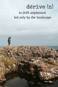 a man standing on top of a rocky cliff next to the ocean with text overlay