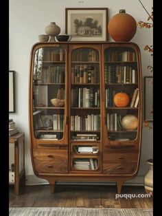 an old bookcase with many books in it and some pumpkins on the top