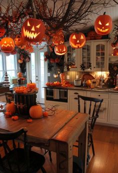 a kitchen decorated for halloween with pumpkins and lights on the ceiling, along with other decorations