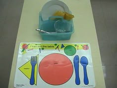 there is a plastic table set with dishes and utensils on it, including a blue bowl