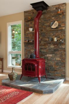 a red stove sitting in the middle of a living room