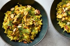 two black bowls filled with rice and nuts on top of a white countertop next to each other