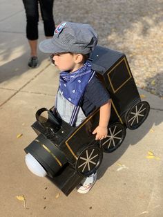 a small child in a costume holding a toy car