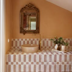 a bathroom with a sink, mirror and vases on the counter in front of it