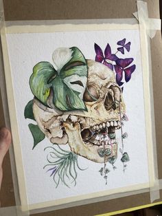 a painting of a skull with flowers on it