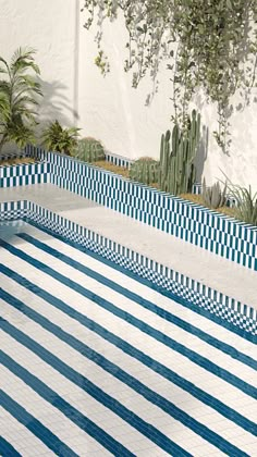 a blue and white tiled pool with succulent plants in the backgroud