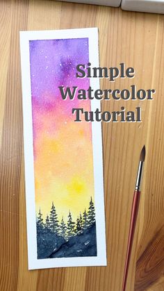 a watercolor bookmark sitting on top of a wooden table