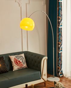 a living room with a couch, coffee table and floor lamp in it's corner