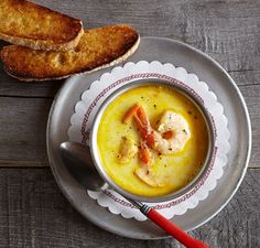 a bowl of soup with bread on the side