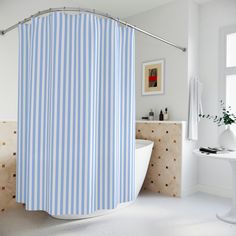 a blue and white striped shower curtain in a bathroom with an oval bathtub next to a sink