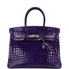 This Birkin is in Ultraviolet Shiny Niloticus crocodile with palladium hardware and has tonal stitching, front flap, two straps with center toggle closure, clochette with lock and two keys, and double rolled handles.The interior is lined with Ultraviolet chevre and has one zip pocket with an Hermes engraved zipper pull and an open pocket on the opposite side.Collection: Q SquareOrigin: FranceCondition: Pre-owned; Mint - This bag retains it shape. The exterior leather has a few very small water s Purple Birkin, Designer Purses And Handbags, Purple Accessories, Birkin 30, Girly Bags, Hermes Birkin 30, Kelly Bag, Luxury Purses, Leather Bag Women