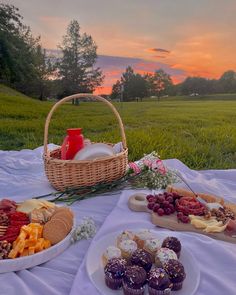 a picnic table with food and drinks on it in the middle of an open field