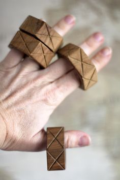 two wooden rings in the palm of someone's hand with their fingers on them