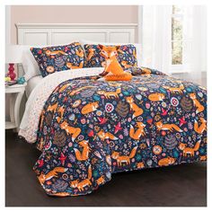 a bed covered in a blue and orange comforter