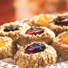 some cookies are sitting on a plate and have fruit toppings in them to make it look like they're going out of the oven