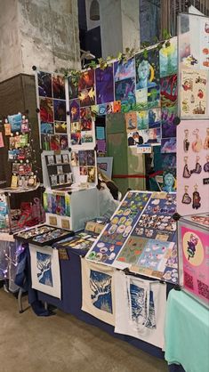 an outdoor market with various items for sale on the tables and in front of them