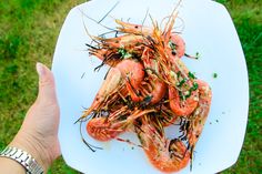 a person holding up a plate with shrimp on it