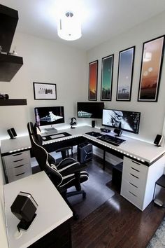 an office with two desks and three computer screens on the wall, all in black and white