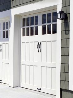 two white garage doors on the side of a house