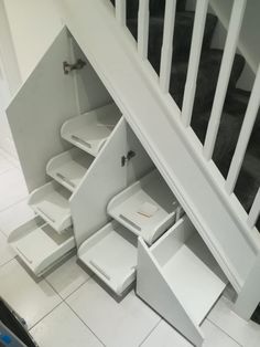 an under stair storage unit in a house with white walls and flooring underneath the stairs