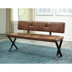 a brown bench sitting on top of a blue rug