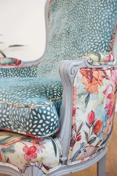 an upholstered chair with floral fabric on it