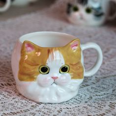 a close up of a cat mug on a table