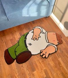 a rug with a cartoon character laying on the floor in front of a blue couch