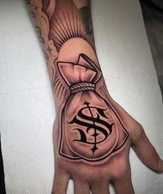 a hand with a money bag tattoo on it