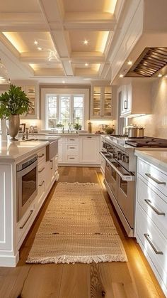 a large kitchen with white cabinets and wood flooring, along with an area rug on the floor