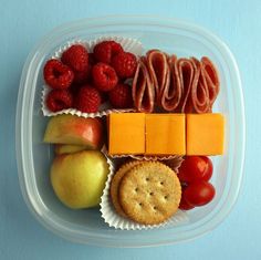 a plastic container filled with fruit and crackers