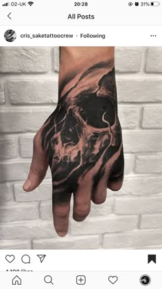 a man's hand with a skull on it, and the other hand is shown in