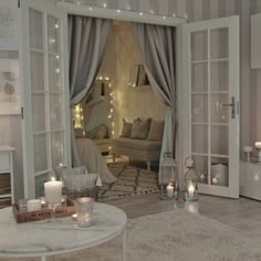 a living room filled with lots of furniture and candles on top of the table in front of an open door